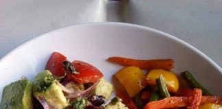 CHICKEN WINGS SERVED WITH PAN FRIED VEGES AND AVOCADO SALAD.