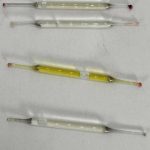 What’s this? Found under a bathroom vanity during remodeling—small glass tubes, 2 inches long, filled with liquid. Any ideas?