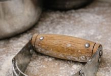Spotted this U-shaped tool with multiple metal blades in my grandmother’s baking bin. It has a wooden handle but looks like some kind of strange knuckles.