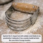 Spotted this U-shaped tool with multiple metal blades in my grandmother’s baking bin. It has a wooden handle but looks like some kind of strange knuckles.