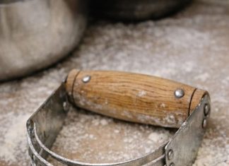 Spotted this U-shaped tool with multiple metal blades in my grandmother’s baking bin. It has a wooden handle but looks like some kind of strange knuckles.