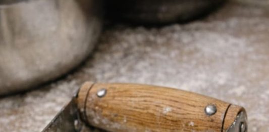 Spotted this U-shaped tool with multiple metal blades in my grandmother’s baking bin. It has a wooden handle but looks like some kind of strange knuckles.