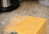 I just got home from the store and opened this expensive block of cheddar to make dinner. There is a small spot of green fuzz on the corner, but the rest of the block looks completely fine. Do I just