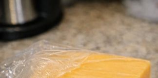 I just got home from the store and opened this expensive block of cheddar to make dinner. There is a small spot of green fuzz on the corner, but the rest of the block looks completely fine. Do I just