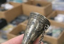 Digging through a junk bin at a rummage sale and found this ornate metal cone. It has a tiny pin attached to a chain and a handle that folds out into a tripod. What in the world is this thing?