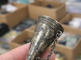 Digging through a junk bin at a rummage sale and found this ornate metal cone. It has a tiny pin attached to a chain and a handle that folds out into a tripod. What in the world is this thing?
