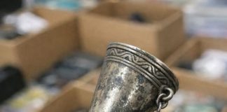 Digging through a junk bin at a rummage sale and found this ornate metal cone. It has a tiny pin attached to a chain and a handle that folds out into a tripod. What in the world is this thing?