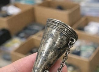 Digging through a junk bin at a rummage sale and found this ornate metal cone. It has a tiny pin attached to a chain and a handle that folds out into a tripod. What in the world is this thing?